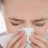 woman-sneezing-into-tissue