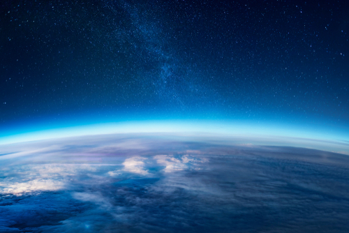 Photograph of the earth from space with visible atmospheric glow.