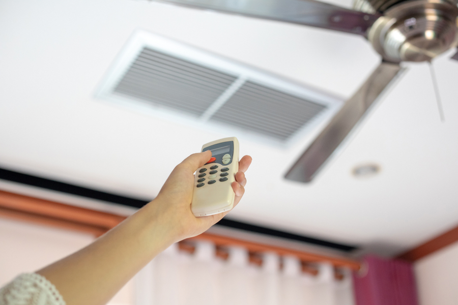 A remote control is used to change the direction of a ceiling fan.