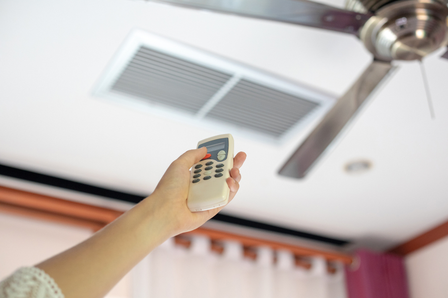 A remote control is used to change the direction of a ceiling fan.
