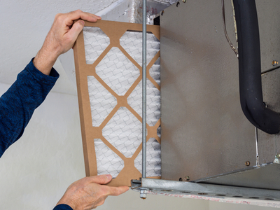 A person replacing an air conditioner filter