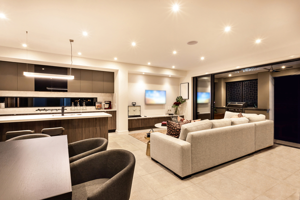 Cream and chocolate brown modern living room and kitchen illuminated with can lights