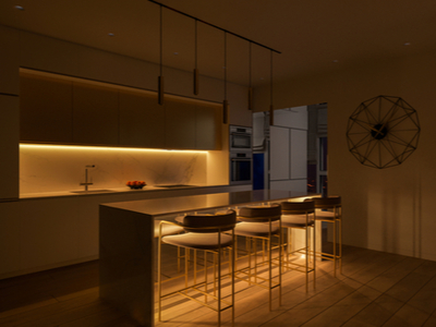 Modern kitchen island and barstools illuminated with yellow hued task lighting