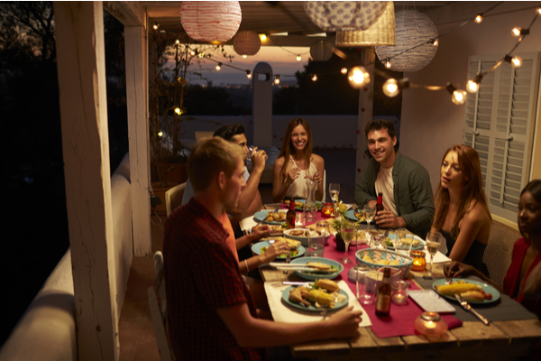 friends eating dinner on dimly lit patio