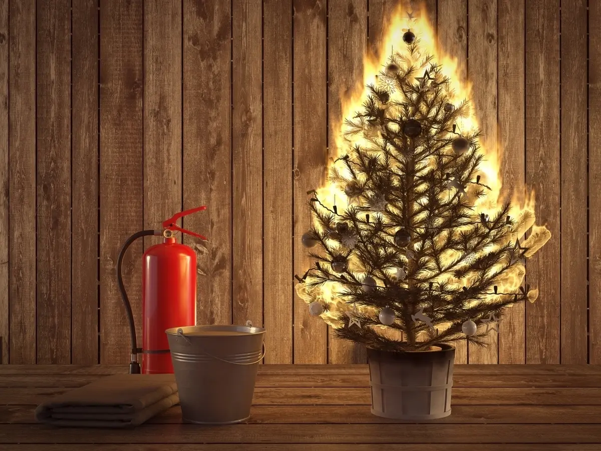 christmas tree on fire next to a fire extinguisher
