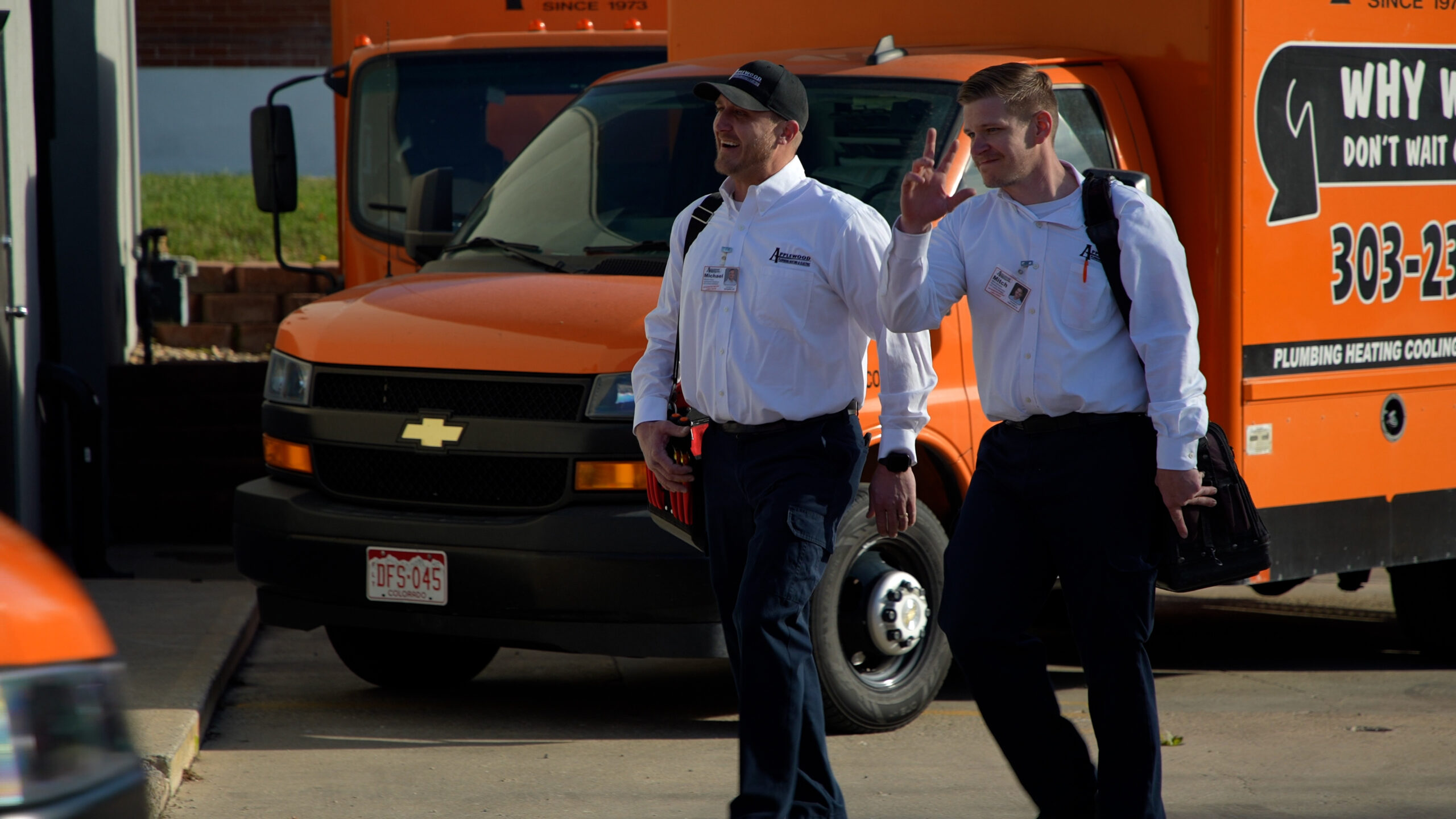 Applewood employees smiling and walking in front of Applewood Trucks.