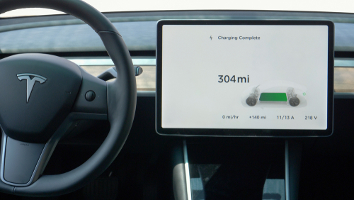 The dashboard display on a Tesla shows a fully charged vehicle with 304 travel miles.