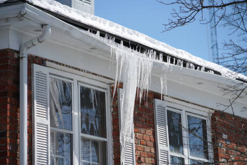 A large ice dam tears at a home's soffit. 