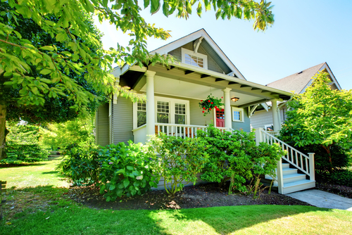 A house with shade trees planted near it. 