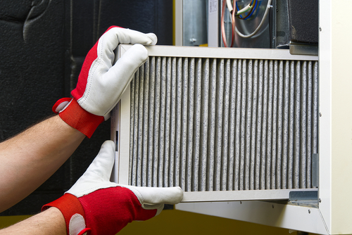 gloved hands replacing an air filter
