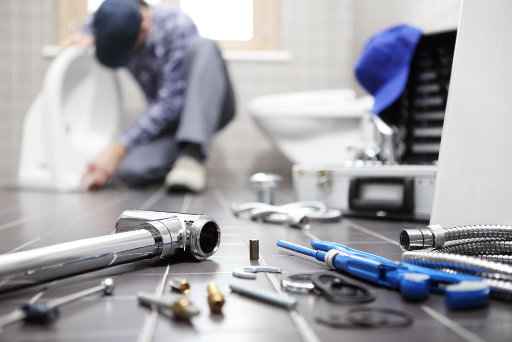 A plumber works to upgrade a home’s toilet.