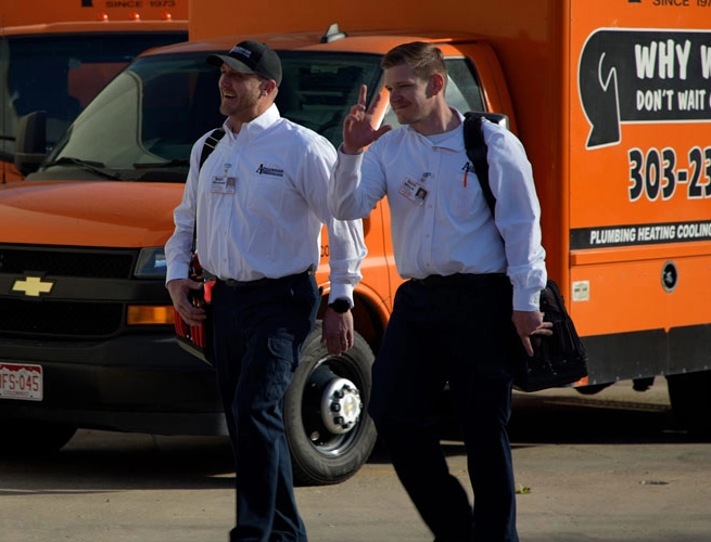 Applewood employees smiling and walking in front of Applewood Trucks.