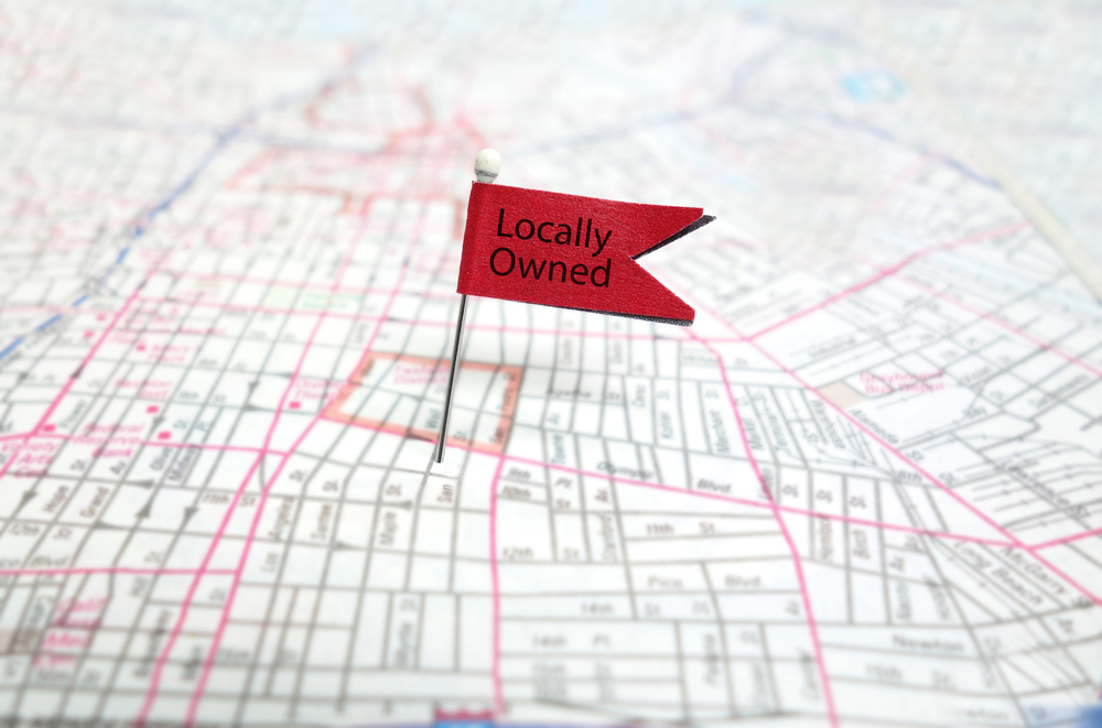 Map with a red flag pinned in it saying “Locally Owned.”