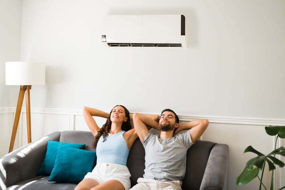 A couple relaxes beneath their air conditioning vent.