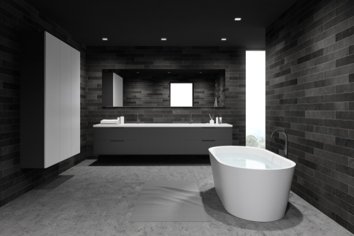 A sleek, modern bathroom with black and gray tile and a white bathtub.