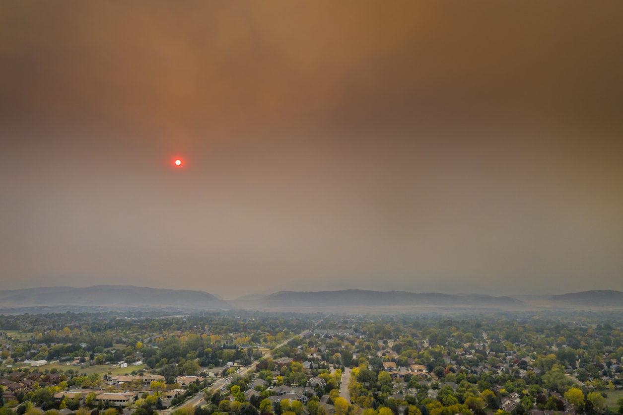 Wildfire smoke haze over a Colorado neighborhood affecting outdoor air quality.