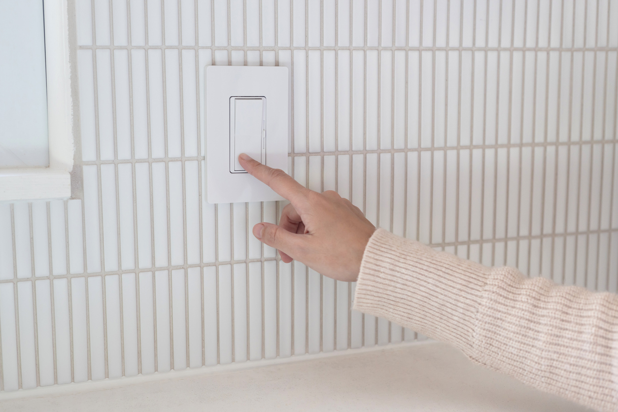 A person turning the light off at the switch